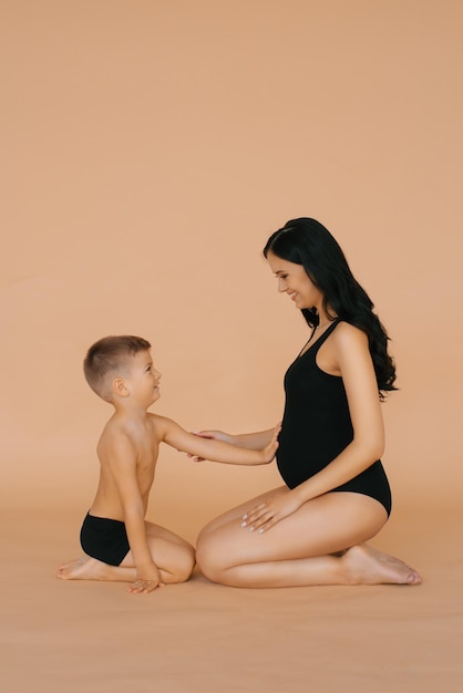 Un petit garçon tient ses mains sur le ventre de sa mère enceinte