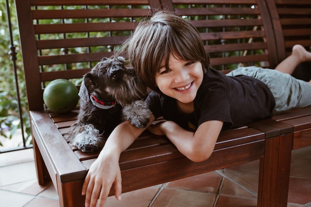 Photo un petit garçon avec ton ami schnauzer nain