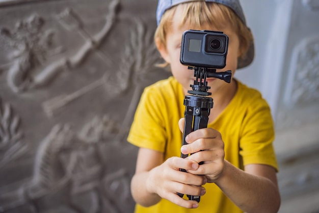 Un petit garçon tourne une vidéo sur une caméra d'action