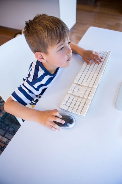 Petit garçon utilisant l&#39;ordinateur dans le salon