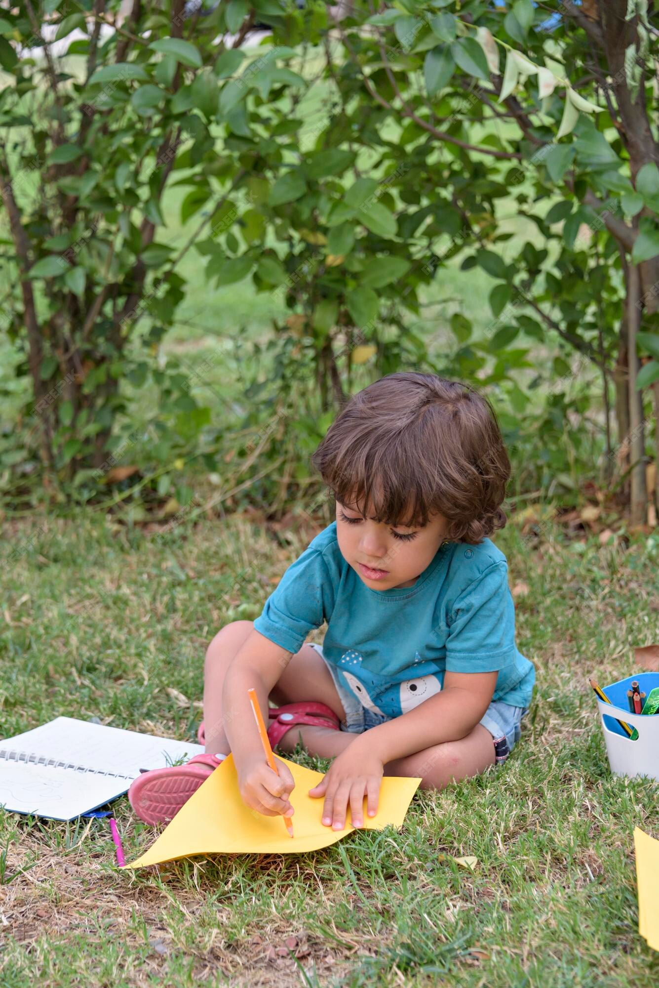 Petit Garçon Utilise Un Stylo Magique Pour Dessiner Des Images Dans Un  Livre Sur Une Table En Bois Dans Le Parc Avec L'expression Du Visage De  Détermination