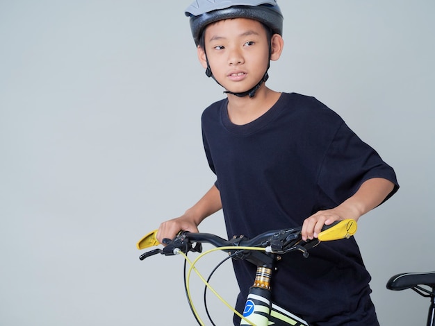 Petit garçon avec vélo sur fond clair