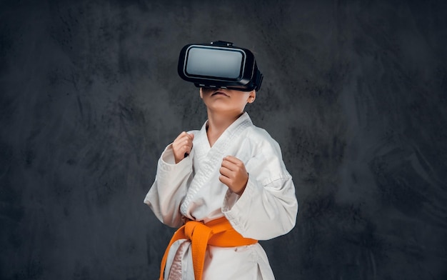 Petit garçon vêtu d'un kimono blanc avec des lunettes VR sur la tête.