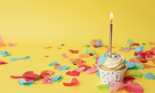 Un petit gâteau d'anniversaire coloré avec une bougie colorée