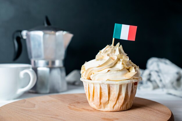 Petit gâteau à la crème d'amandes fraîchement cuit et chapelure d'amandes avec drapeau italien pour le thé du matin