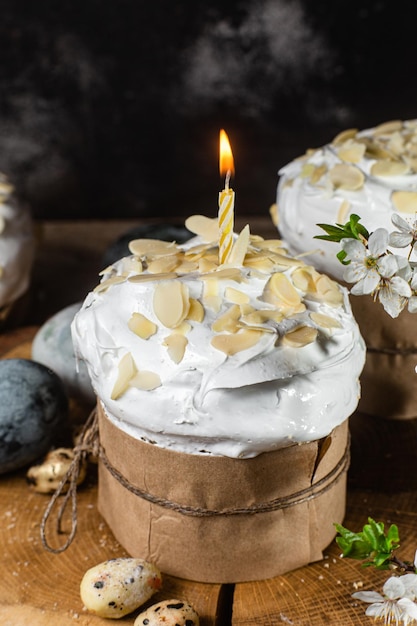 Petit gâteau de Pâques avec des pétales de meringue et d'amande sur un fond en bois