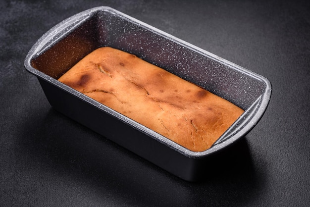 Petit gâteau rectangulaire cuit au four avec des raisins secs et du chocolat sur un fond de béton foncé Délicieuses pâtisseries maison