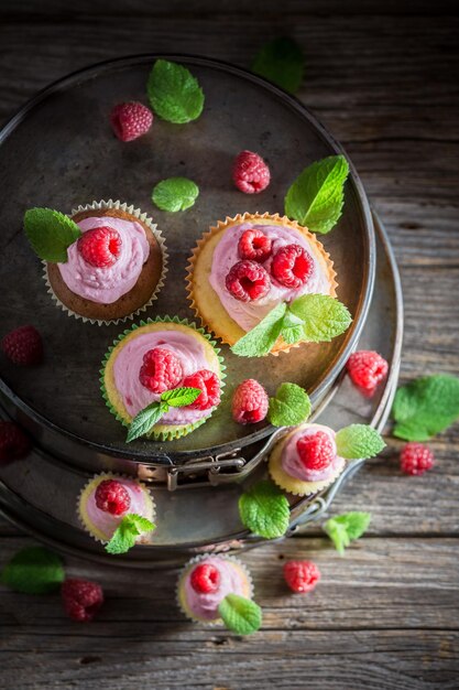 Petit gâteau savoureux de framboise avec des baies et de la crème rose