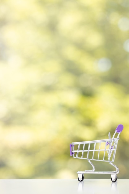 Petit jouet de caddie sur le fond vert d'été