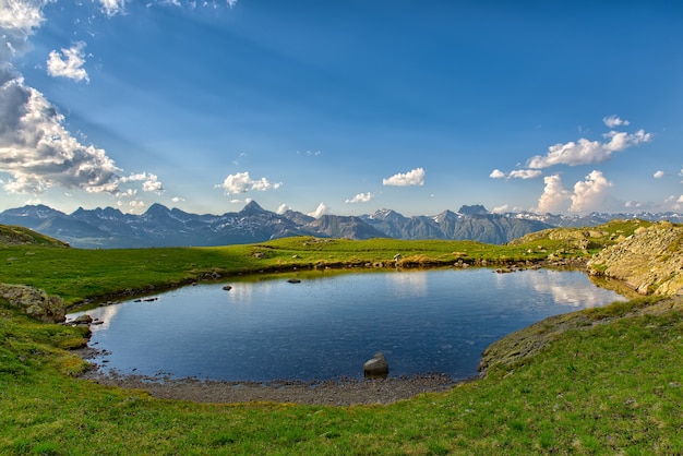 Petit lac de haute montagne et ciel lumineux