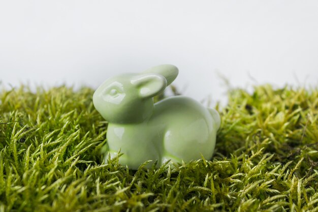 Petit lapin en porcelaine verte sur l'herbe verte