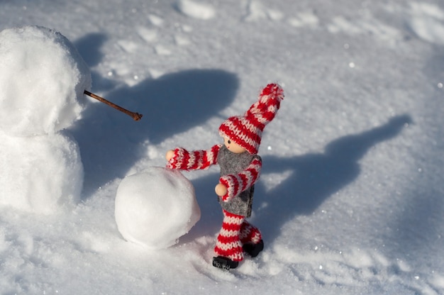 Petit mannequin de jouet construit un bonhomme de neige