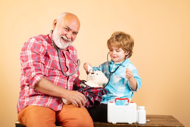 Petit médecin examinant un homme âgé par stéthoscope petit médecin souriant tout en montrant une tablette à l'ol