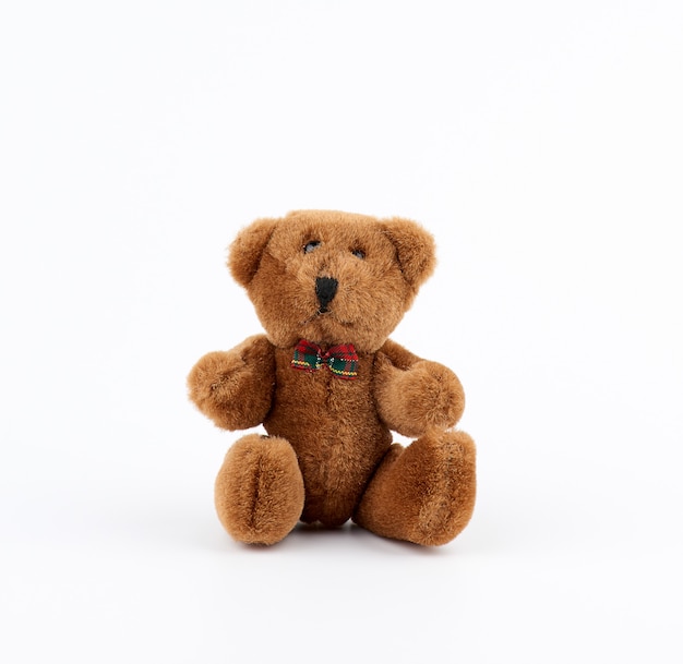 Petit ours en peluche brun mignon avec un arc sur le cou