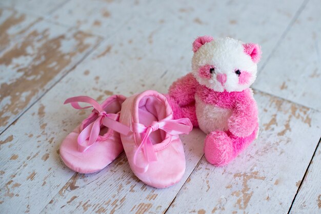 Petit ours en peluche et chaussures pour enfants sur fond de bois