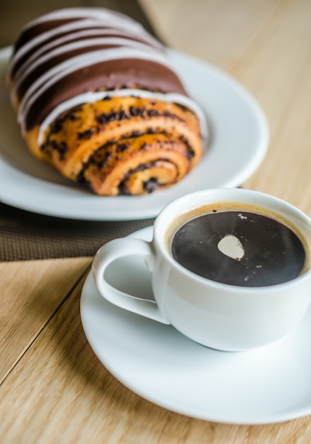 Petit pain au chocolat avec une tasse de café