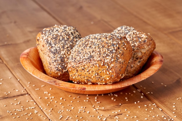 Petit pain aux graines de pavot et sésame sur la table en bois.