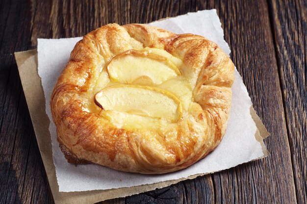 Petit pain aux pommes sur une table en bois foncé