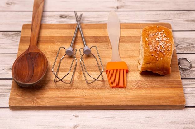 Petit pain chaud frais et fournitures de cuisine sur un bureau en bois