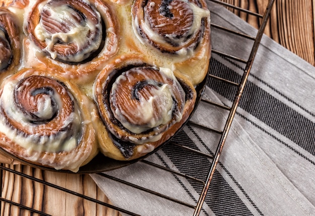 Petit pain avec du thé sur une table en bois sur une grille métallique sur un fond en bois