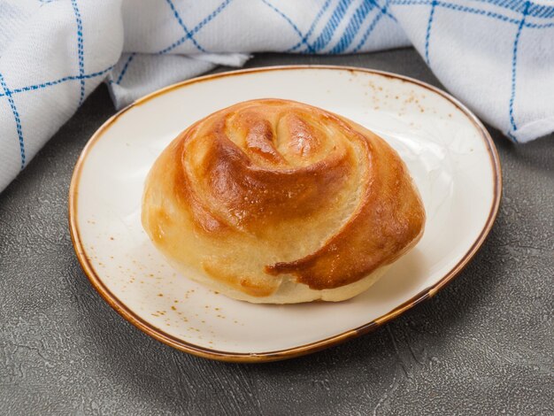 Petit pain fait maison à base de pâte tourbillonnée sur une assiette légère