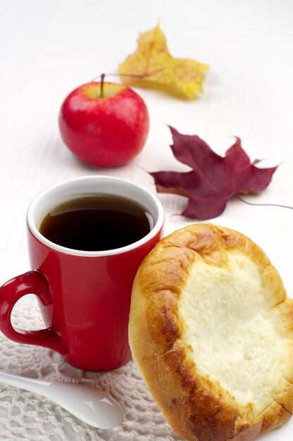 Petit pain sucré avec du fromage cottage et une tasse de thé sur la table