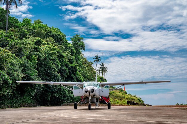 Photo petit parking d'avion à réaction dans la petite île de thaïlande avec la montagne derrière.