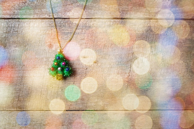 Petit pendentif d'arbre de noël sur une table en bois avec espace de copie vue de dessus bokeh coloré