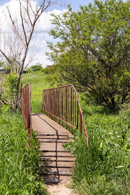 Petit pont de fer avec vieille roue de fer à la campagne.