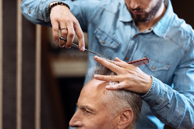 Petit rafraîchissement. Bouchent le portrait du vieil homme aux cheveux gris ayant une coupe de cheveux professionnelle en salon de coiffure.