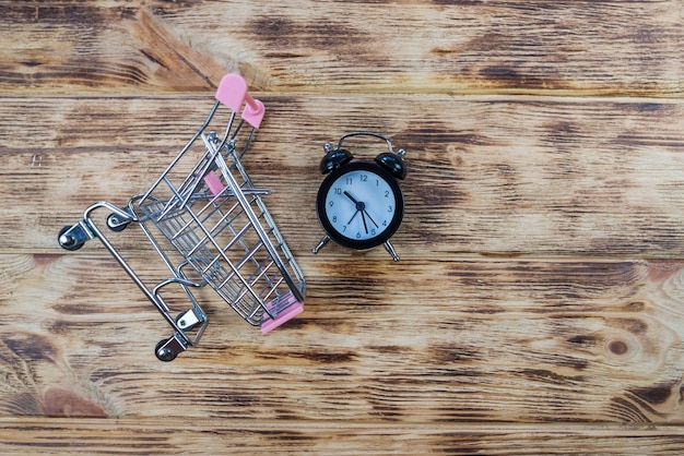 Petit réveil noir et horloge de panier jouet dans le panier manque de temps perte de temps temps d'achat