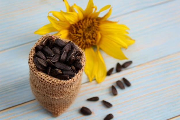 Photo un petit sac se dresse avec des graines de tournesol se trouvant à l'intérieur sur une table en bois