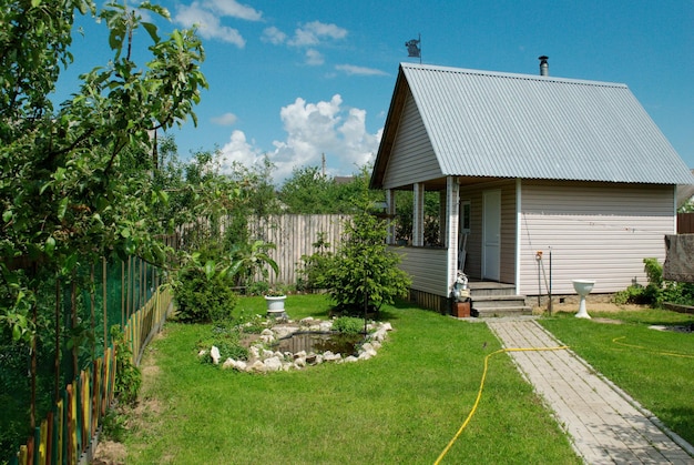 Un petit sauna et un petit étang sur la parcelle de jardin par une journée ensoleillée