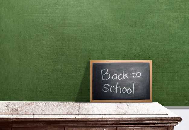 Petit tableau noir avec le texte de la rentrée scolaire sur le bureau