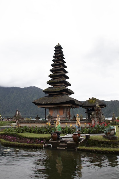 un petit temple avec une montagne en arrière-plan et une petite statue au milieu