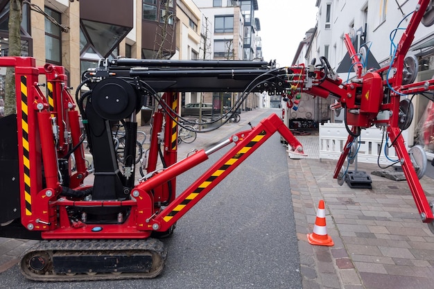 Photo petit tracteur rouge avec des ventouses pour remplacer les vitrines d'un magasin dans une rue étroite de la ville
