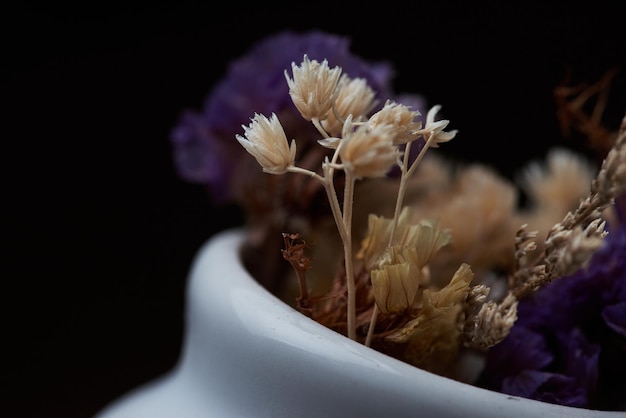 Un petit vase blanc avec une fleur dedans