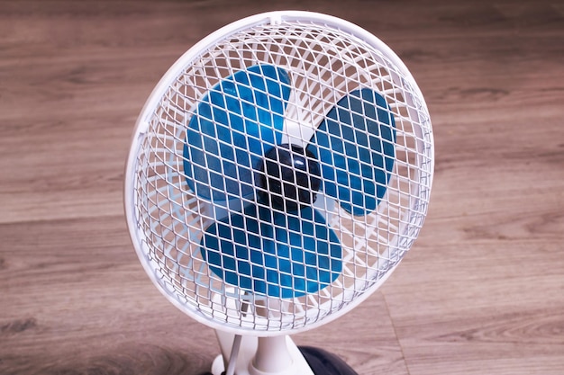 Petit ventilateur sur le plancher en bois libre