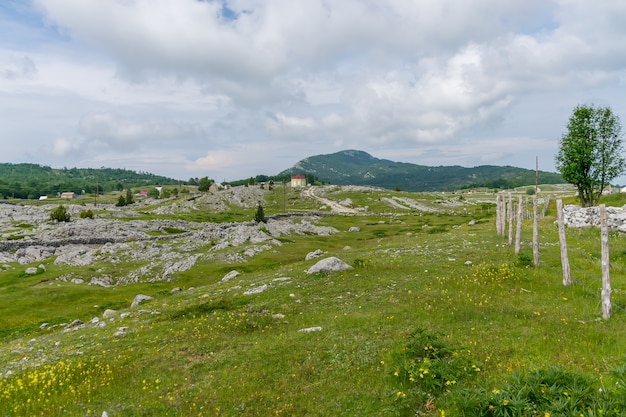 Un petit village est situé au milieu de nombreuses collines et montagnes.