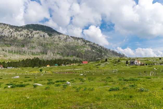 Un petit village est situé parmi de nombreuses collines et montagnes.