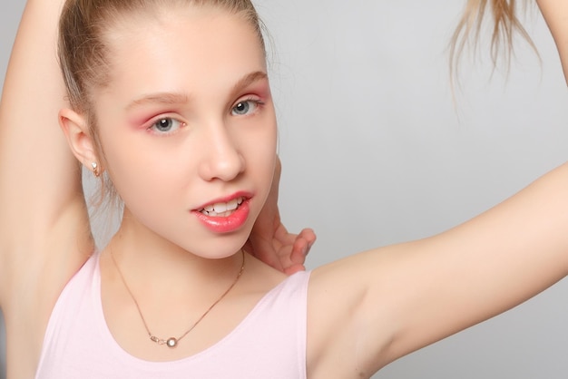 Une petite adorable jeune ballerine fait des poses de ballet et des exercices d'étirement sur le sol à la maison