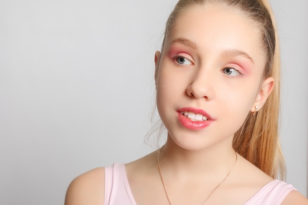 Une petite adorable jeune ballerine fait des poses de ballet et des exercices d'étirement sur le sol à la maison