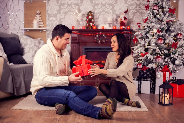 Petite amie et petit ami profitant du jour de noël ensemble. Sapin de Noël.