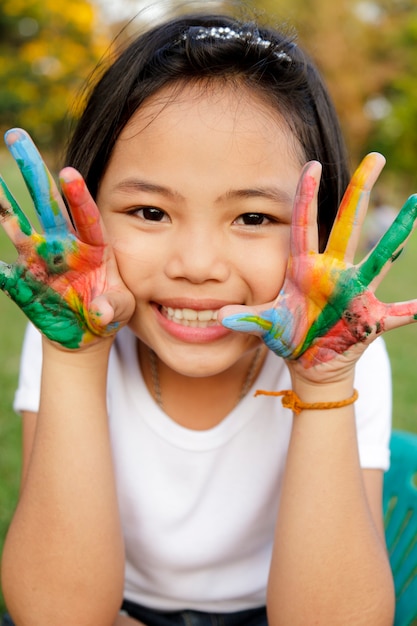 Petite asiat aux mains peintes de peintures colorées