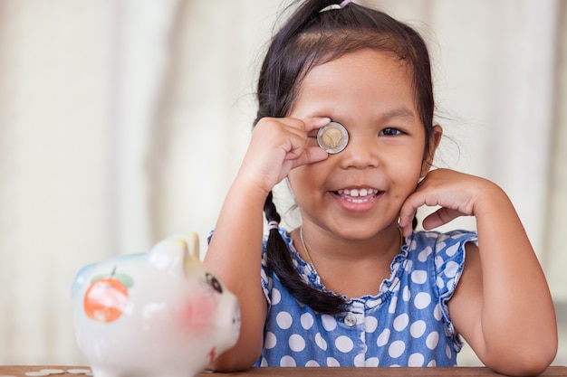 Petite asiat s&#39;amuser à jouer avec des pièces de monnaie