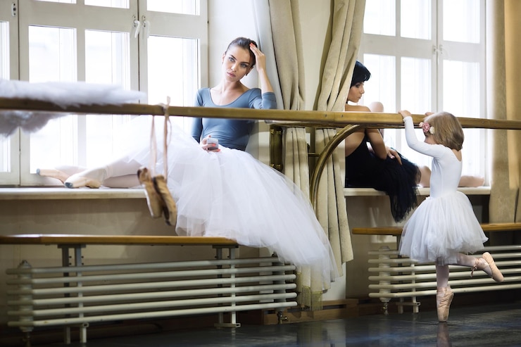 Photo petite ballerine et ballerines adultes en classe de ballet