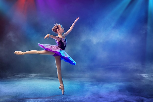 Une petite ballerine japonaise danse sur scène dans un tutu lilas sur pointes ballet classique