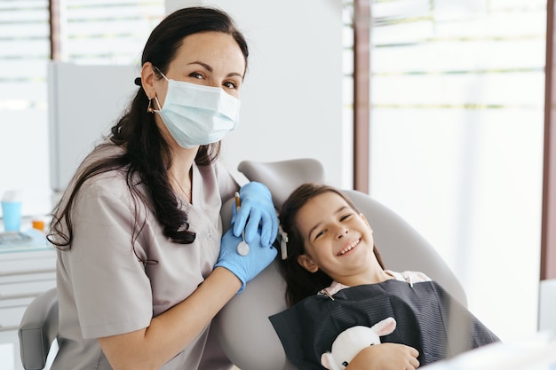 Petite belle fille chez le dentiste regardant et souriant