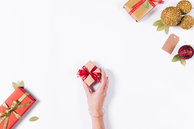 Petite boîte cadeau rouge avec un arc dans la main féminine