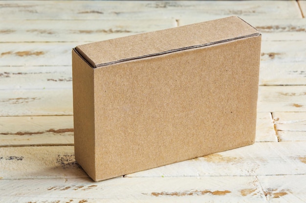 Une petite boîte en carton sur une surface en bois